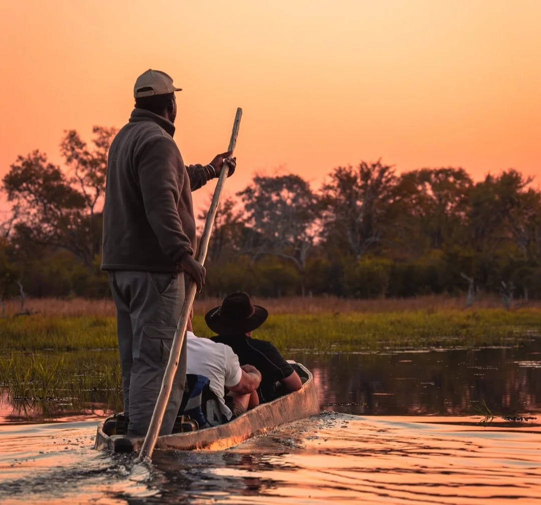 Image of travelers taking a ride in mokoro canoe